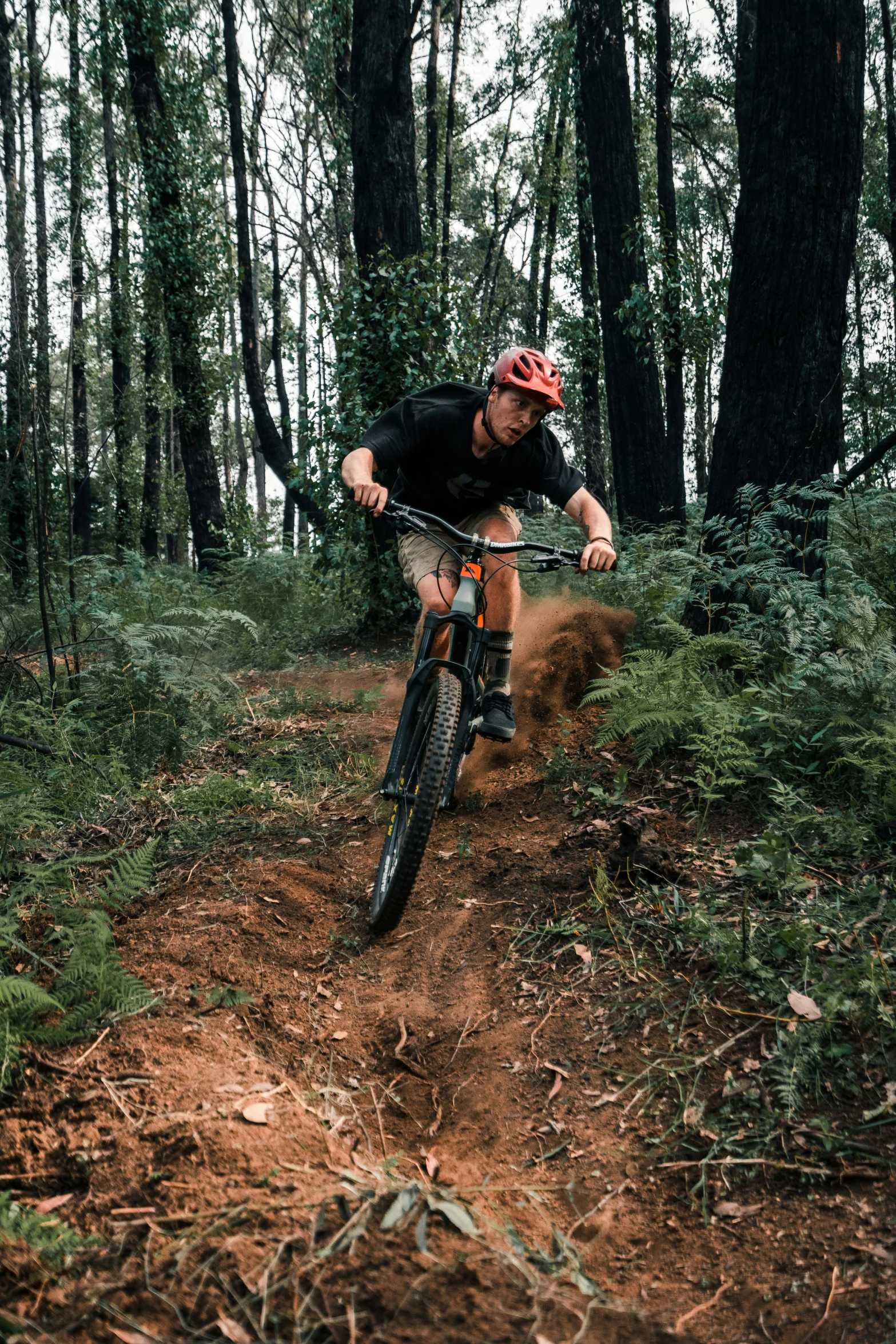 the man is riding his bike on the dirt trail