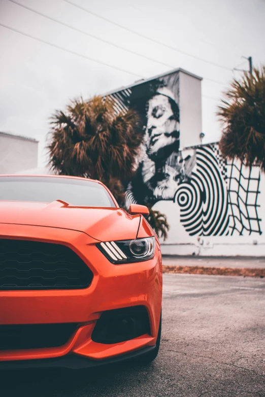 the red car is parked in front of a big building