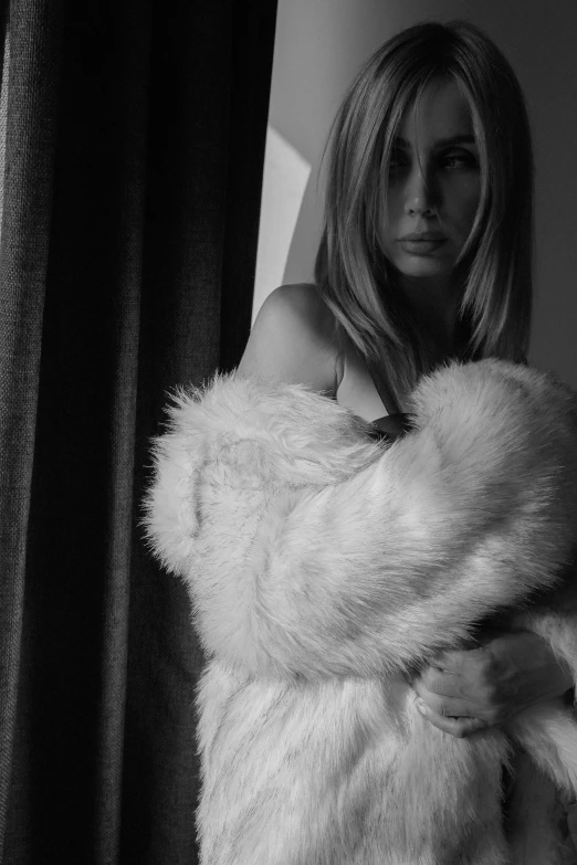 a black and white po of a woman in a fur coat