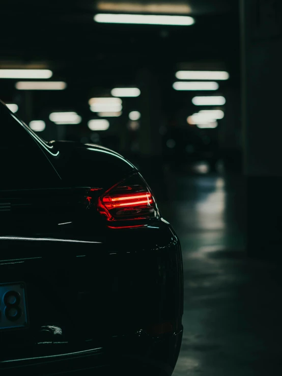 a black sports car parked in a dark parking garage