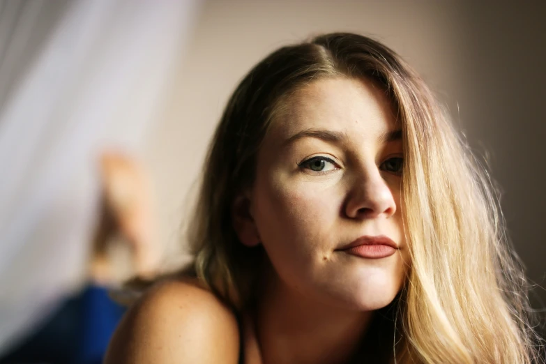 a woman with long hair and blue eyes looking at the camera