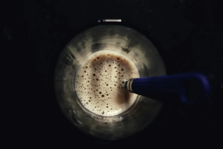 a cup filled with liquid and a blue handle