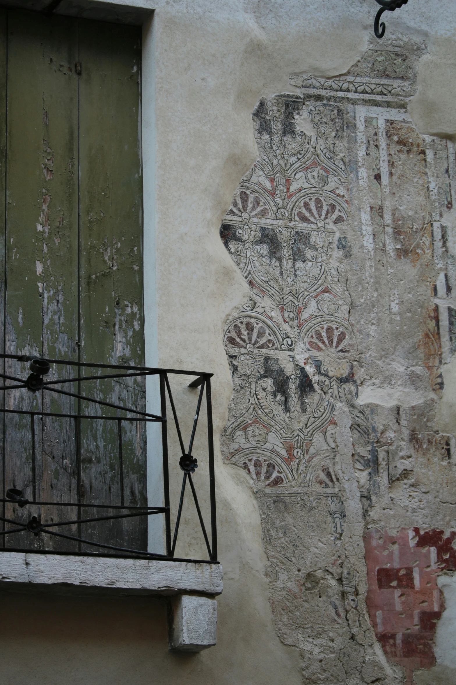 an old window with iron bars and a painted wall