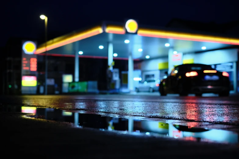 a gas station in the rain at night