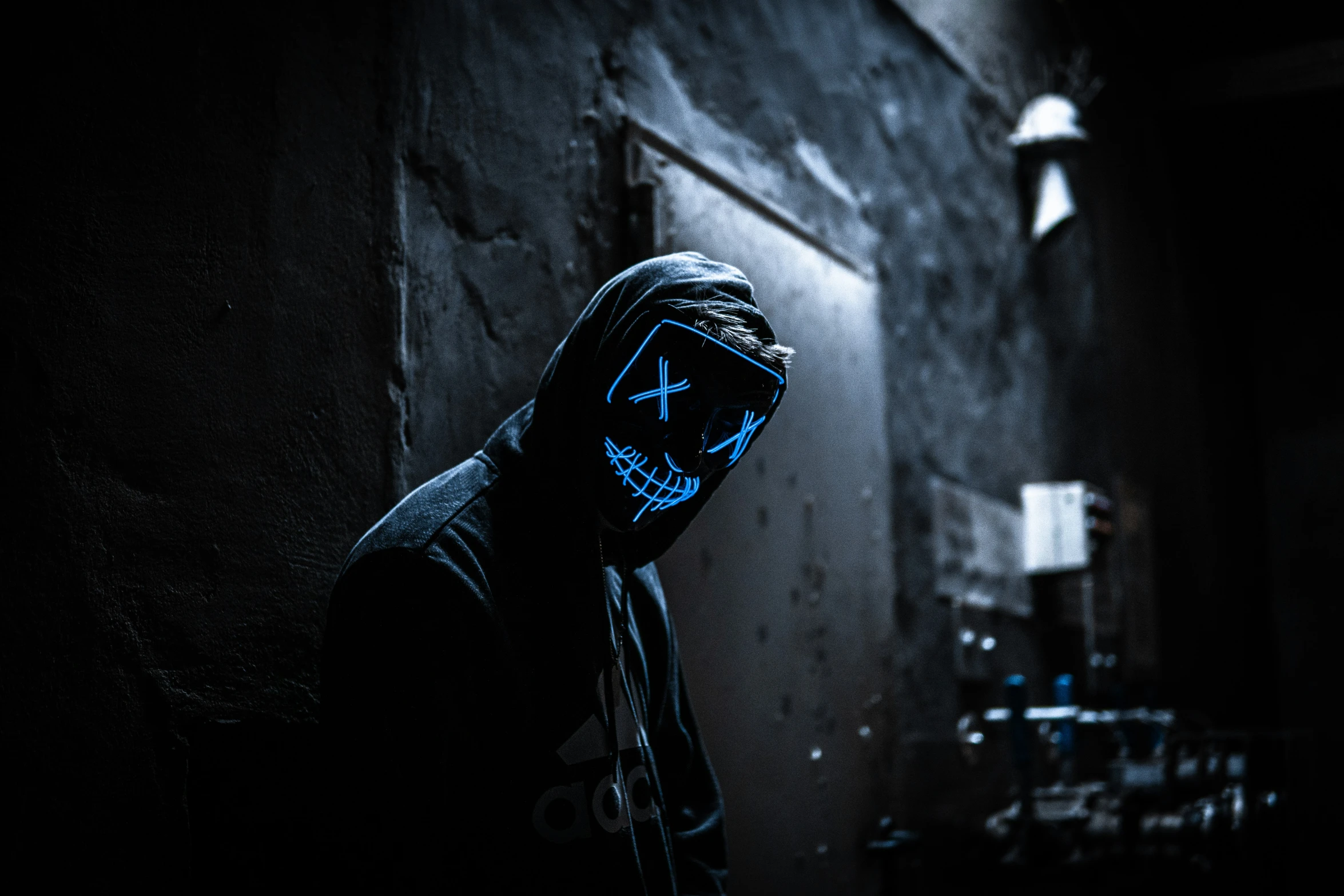 a person with blue light face paint standing in the dark