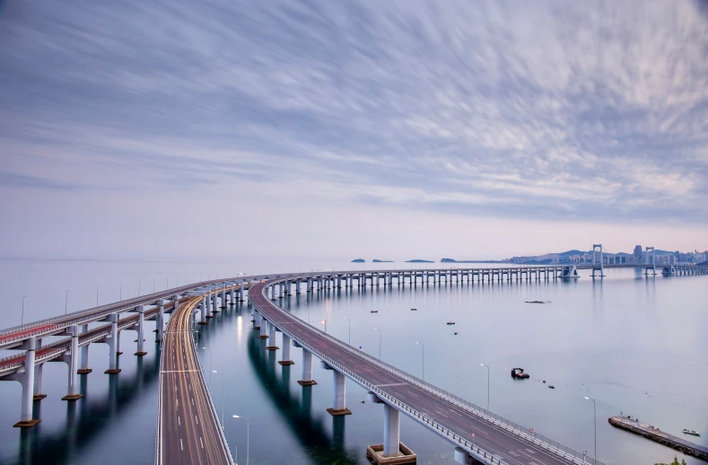 large bridge in large body of water surrounded by tall buildings