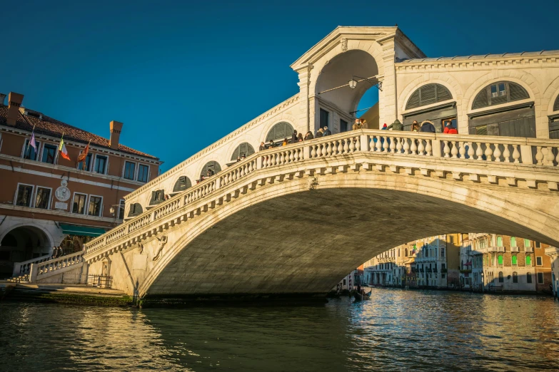 a bridge crossing over some water in front of buildings