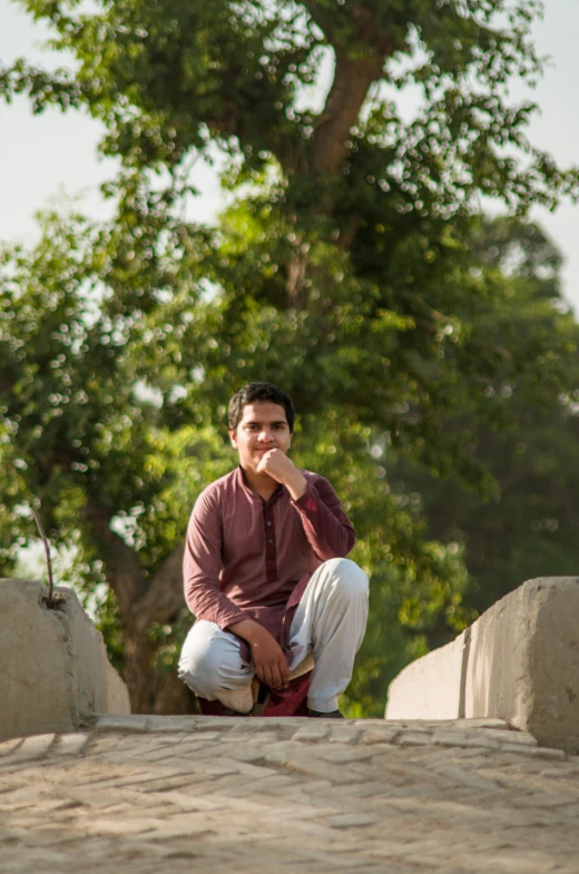 a man sitting on top of a cement slab