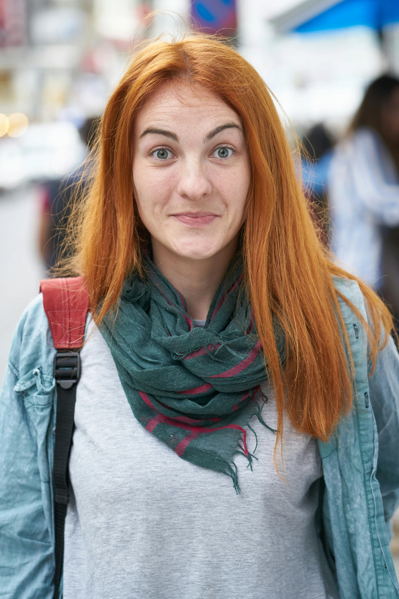 a girl with red hair standing with a backpack