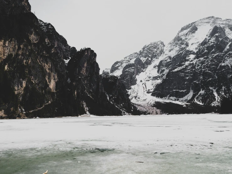 snow covered mountains on the shores of a lake