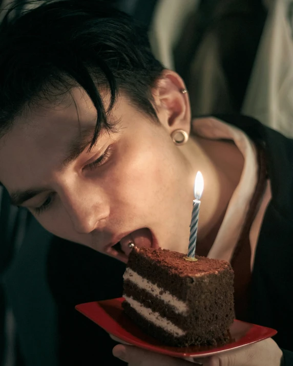 a young man is biting into a slice of cake