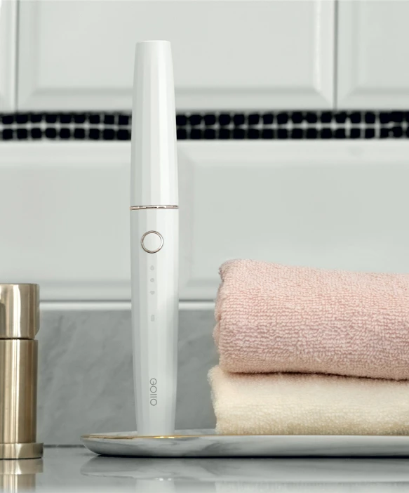 a white electric toothbrush sitting on top of a sink