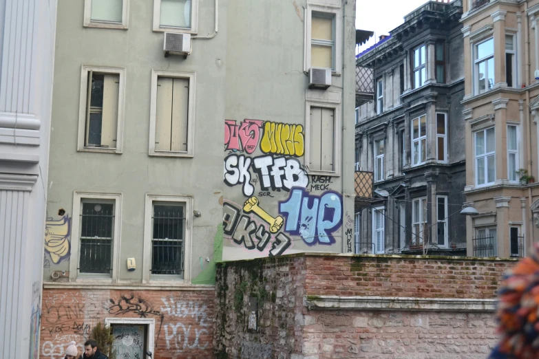 a very large sign by a building with grafitti