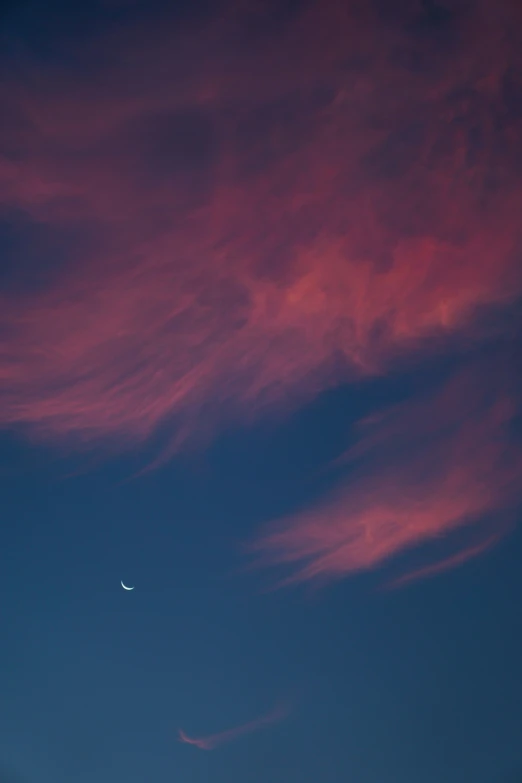 an airplane flying in the air during sunset