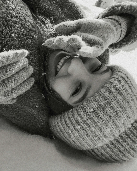 a person laying on the ground laughing with a hat