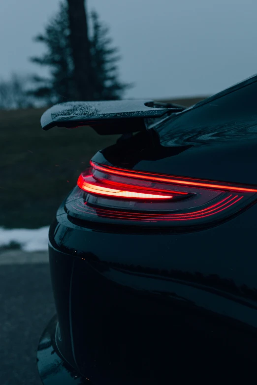 a car with its tail lights on at dusk