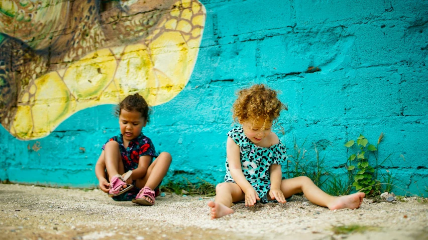 two little s sitting on the side of a wall