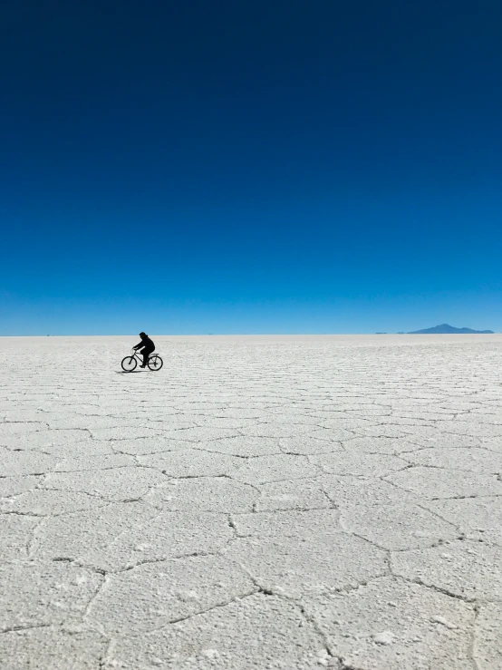 a person riding a bicycle on top of a flat surface