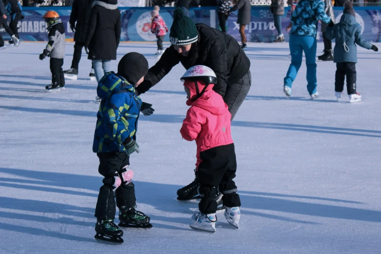 two little children learning to skate on the ice