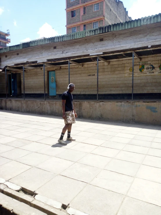 a man walking down the street on his skateboard