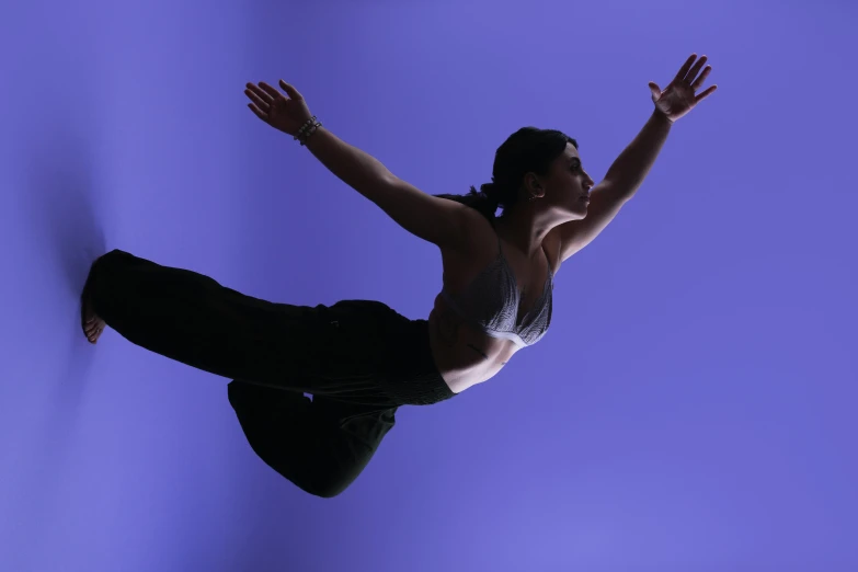 a woman wearing a  standing in the air on top of a pair of heels