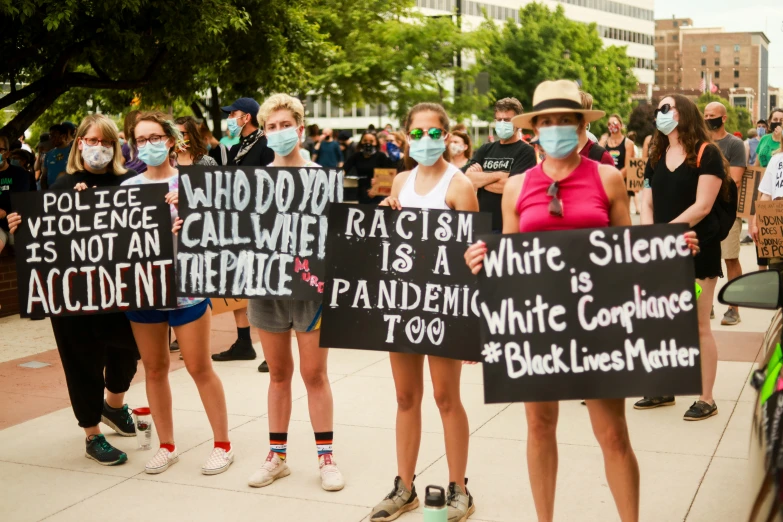 group of protesters standing together holding signs with words on them