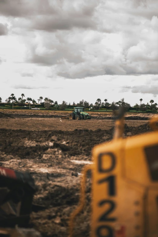 a dirt field with a tractor and vehicle on it