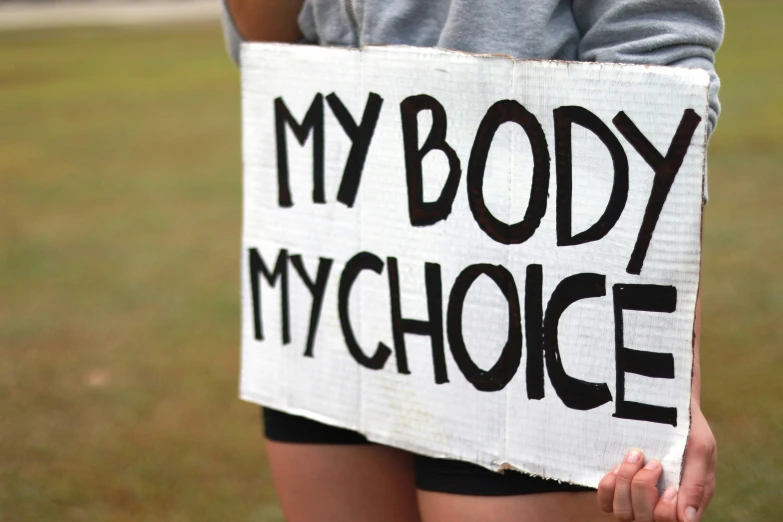 a close up of a person holding a sign