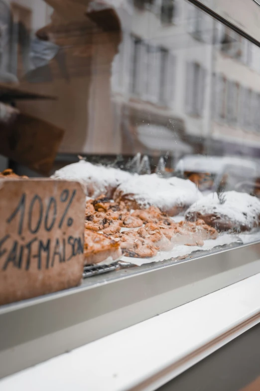 an outside display window with doughnuts and pastry items in it