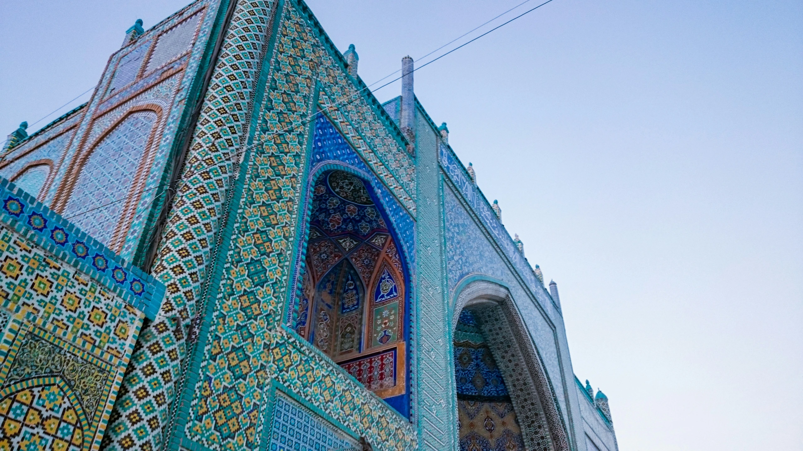 an intricately tiled building with a clock on the wall