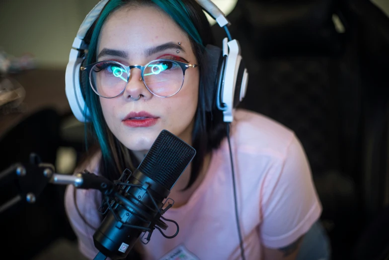 a woman wearing glasses and headphones is holding a microphone
