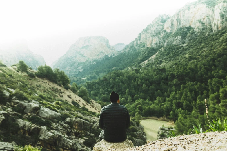 a man looking out over mountains from the side