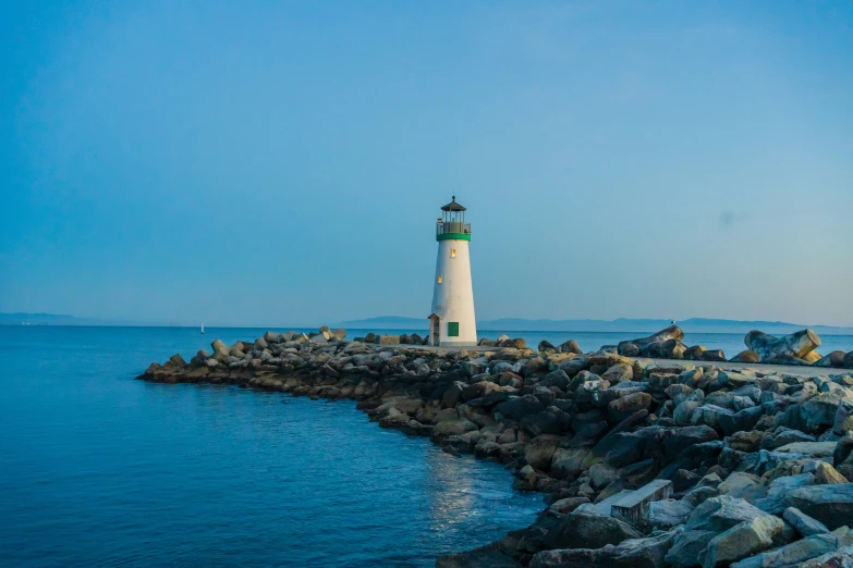 a small white lighthouse in front of some water