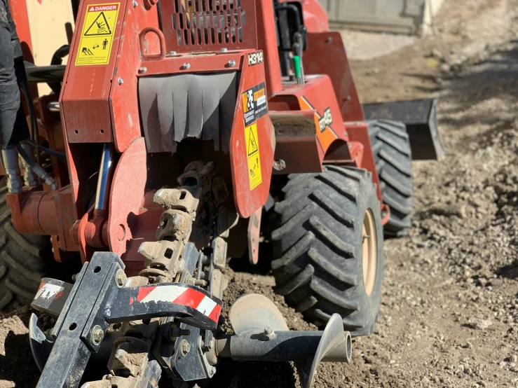 a tractor with wheels and safety equipment parked in dirt