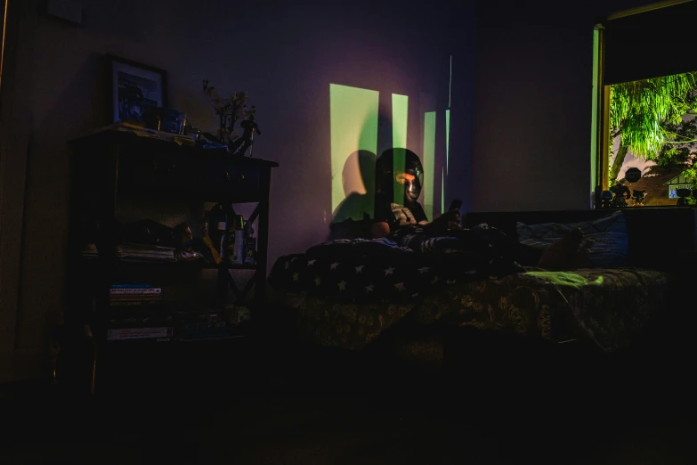 a person is sitting in the dark of a room