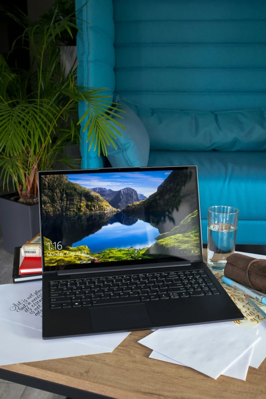 a lap top sitting on a wooden table next to glass