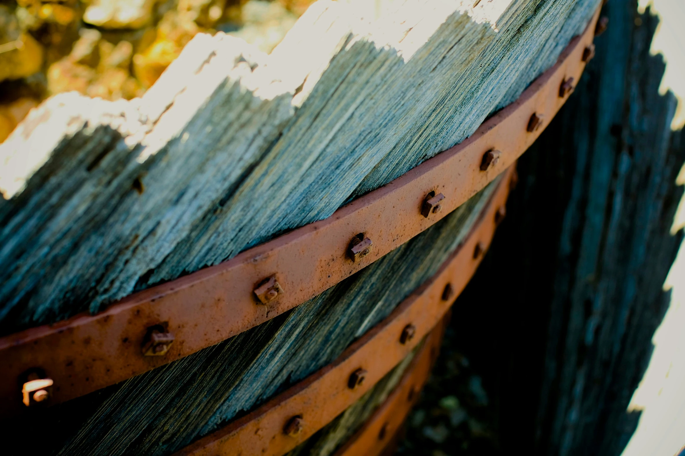 two brown leather beltes are sitting on an old fence