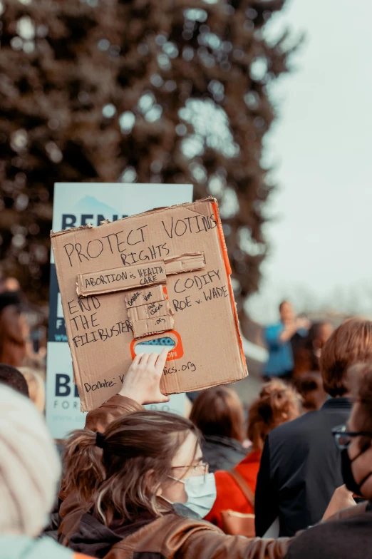 a person in a crowd with a sign