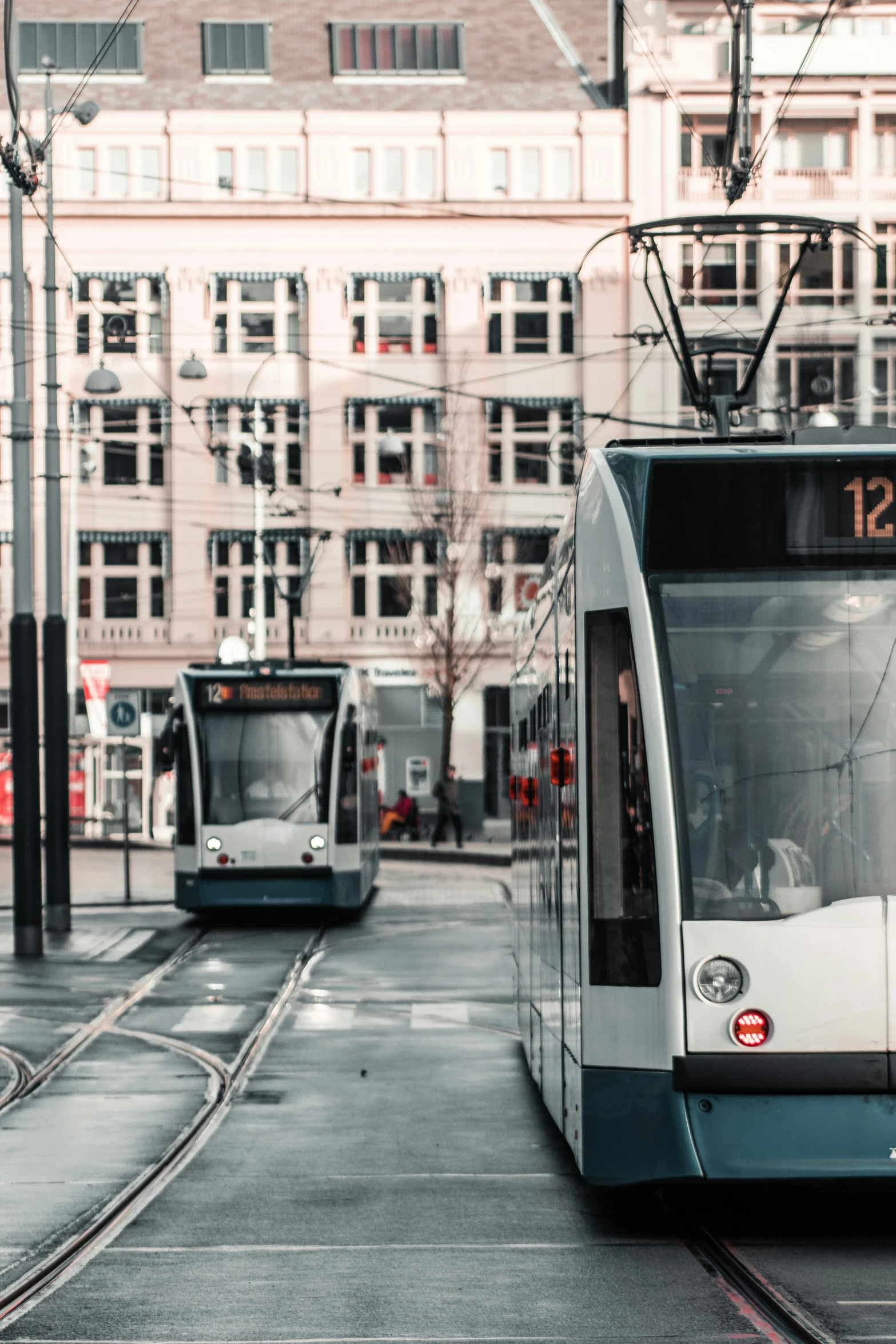 some buildings and two trains traveling down the tracks