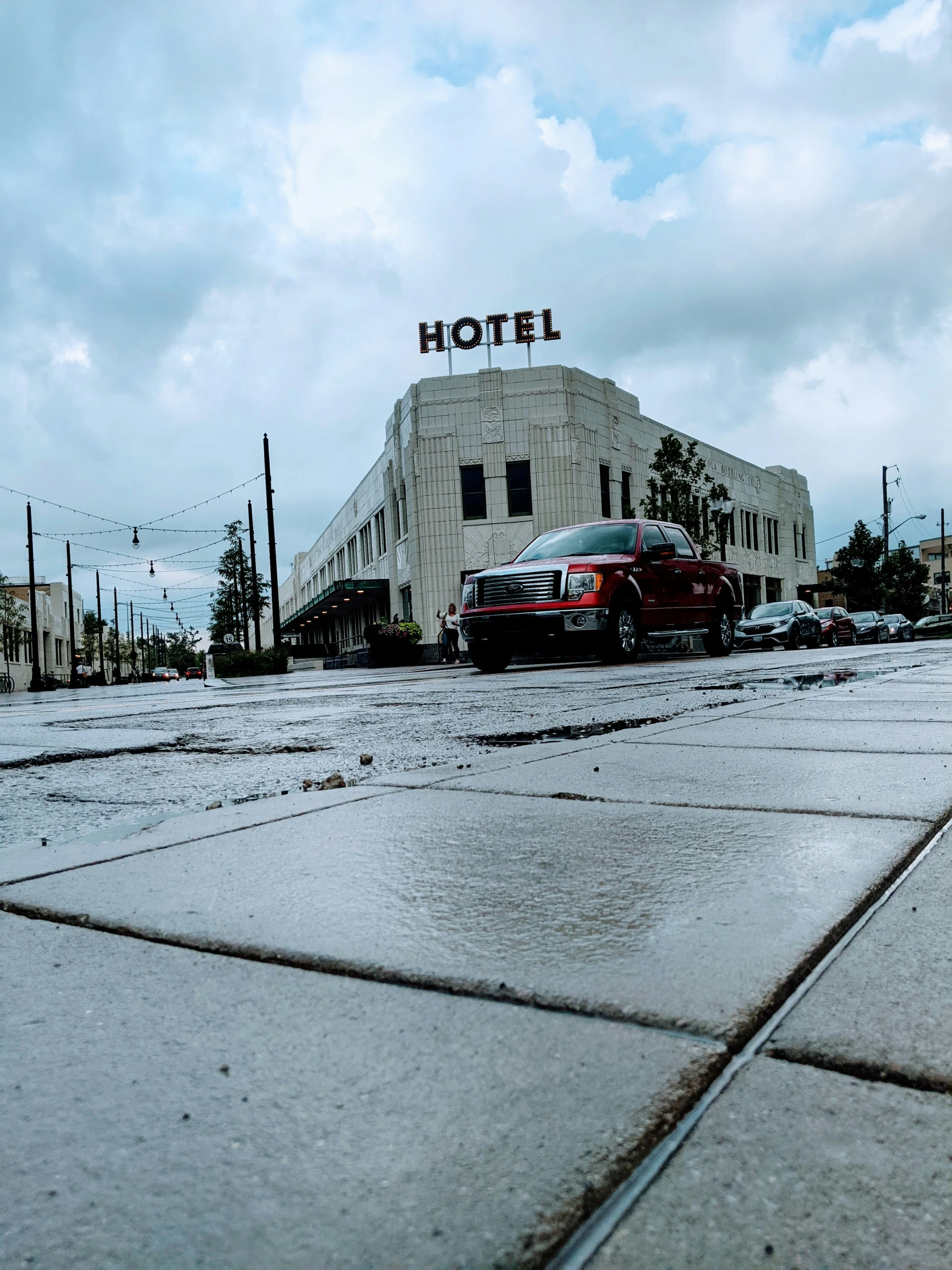 a wet city street with parked cars on it