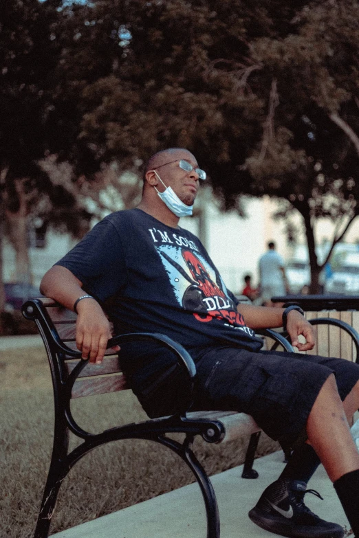 a man wearing ear muffs sitting on a bench