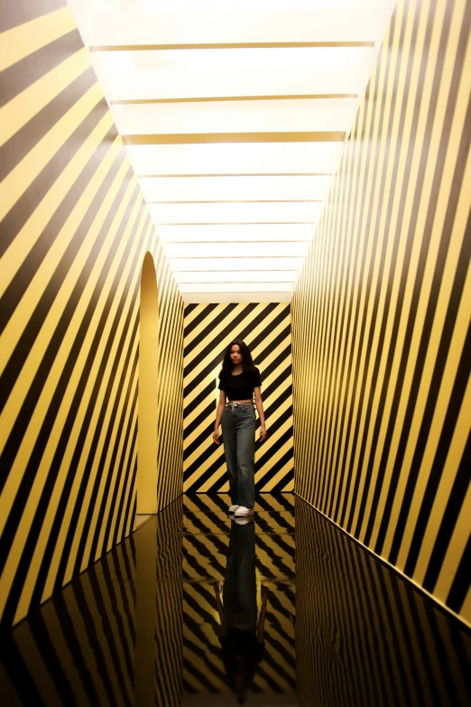 the girl is walking through an unusual striped room