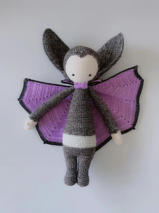 stuffed animal with knitted bat in front