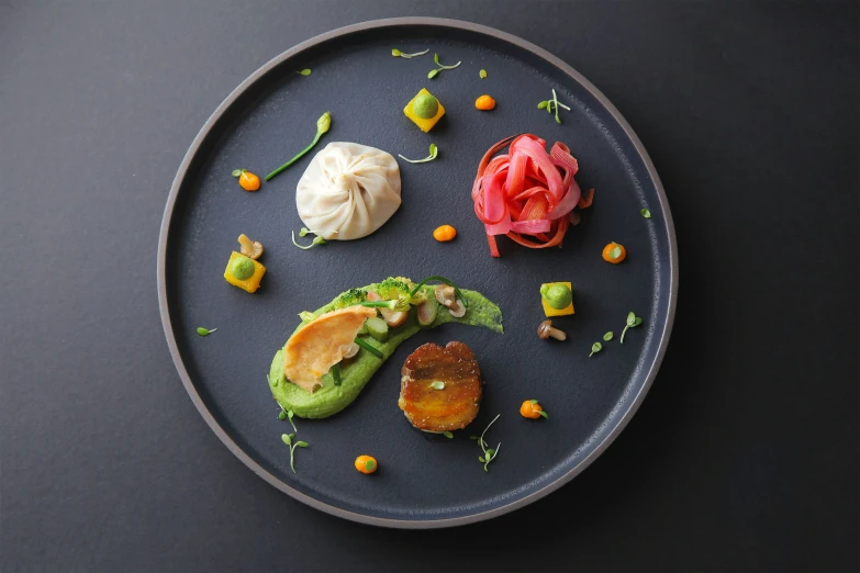 a round, black plate with three appetizers