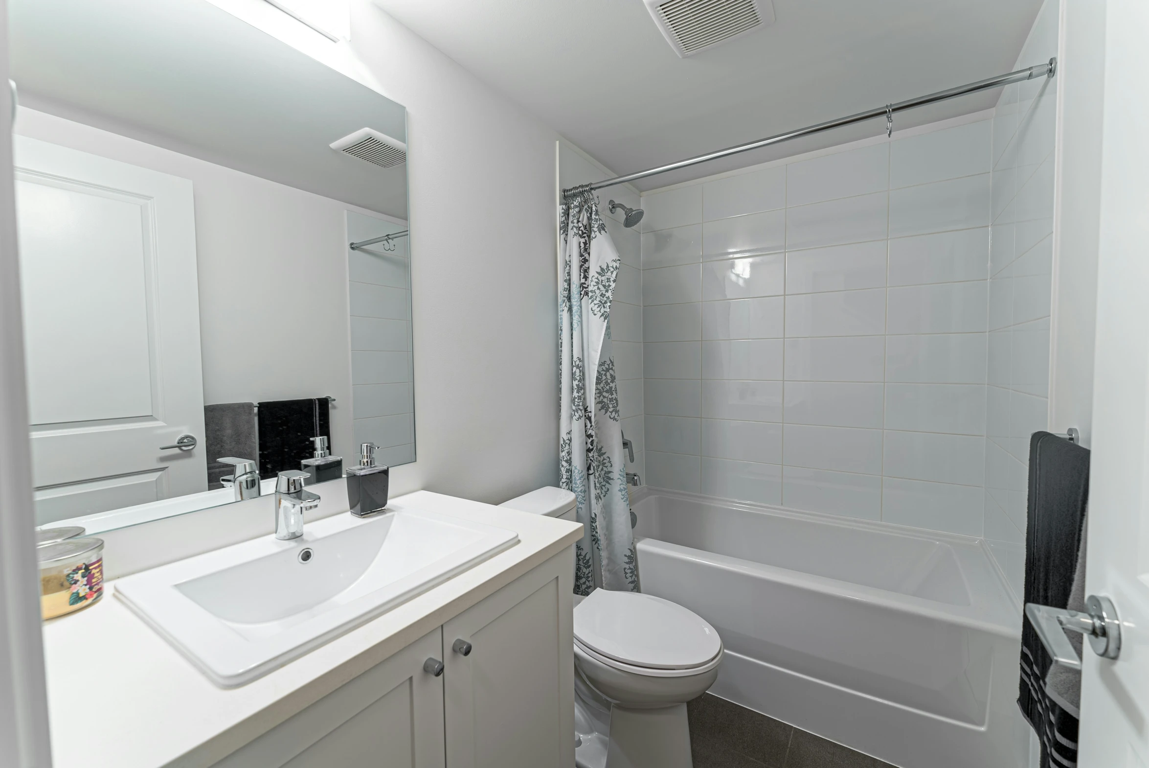 a large bathroom with white fixtures and white tile