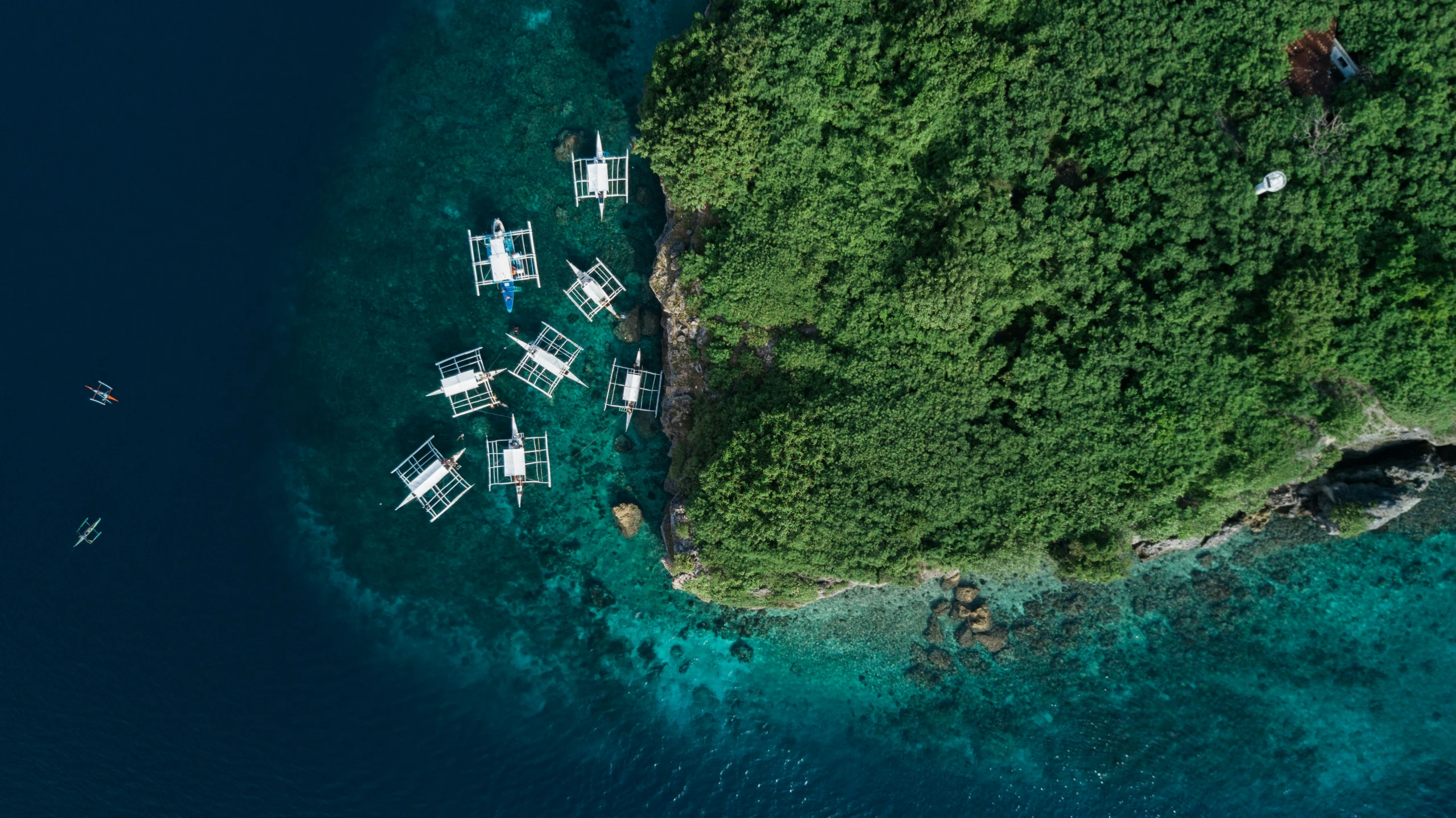 the aerial view of many boats sitting on clear water