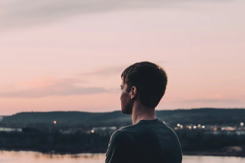 a man standing on the shore overlooking the water