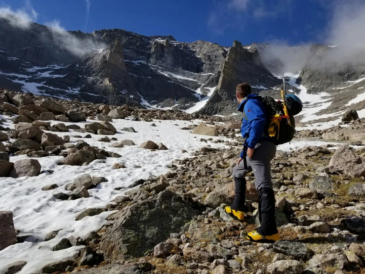 a man standing on top of a rocky mountain with skis