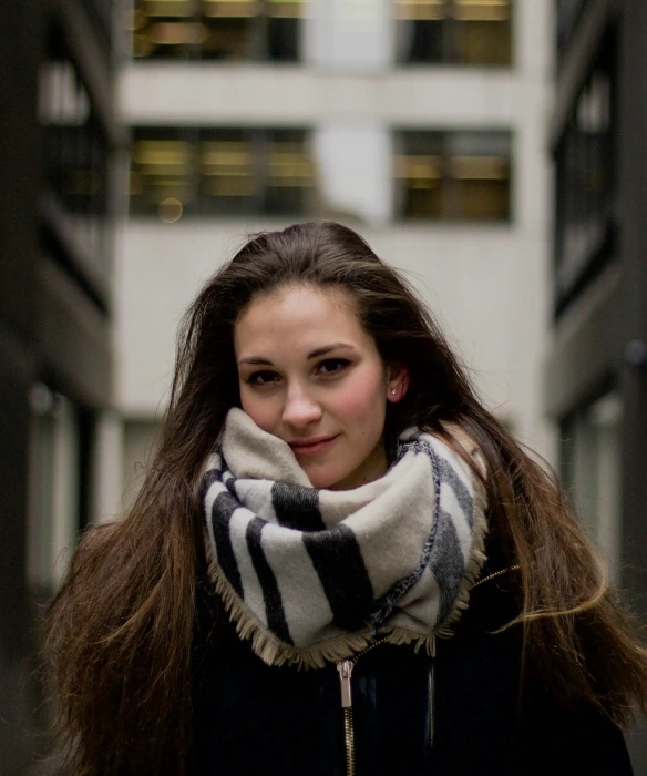 a beautiful young woman with long brown hair wearing a scarf