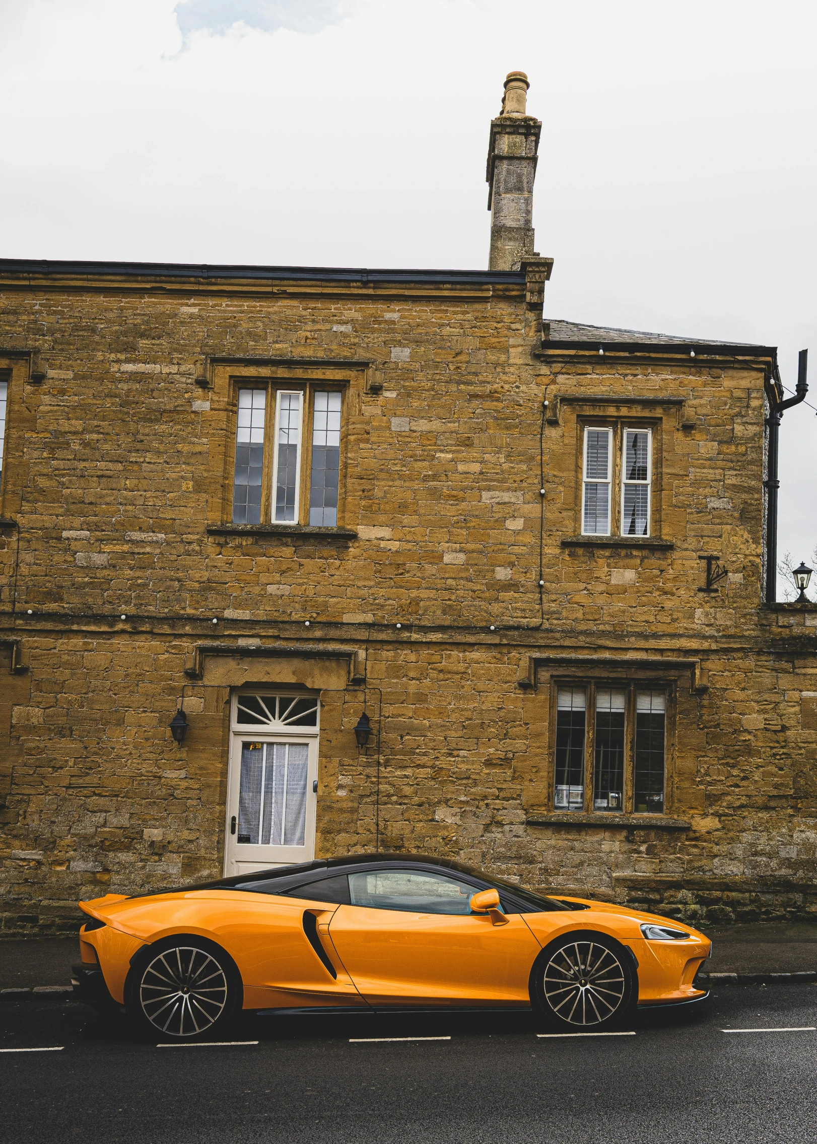 a very nice bright colored sports car parked in front of a house
